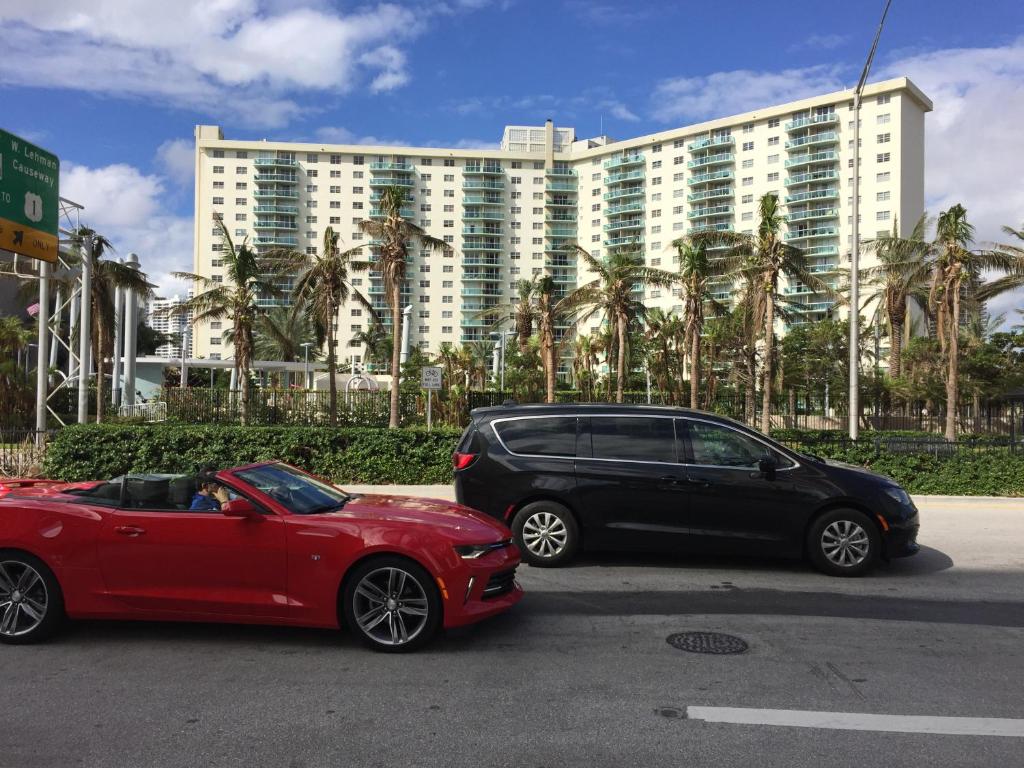 two cars parked in front of a large building at Ocean Reserve STR-01045 in Sunny Isles Beach