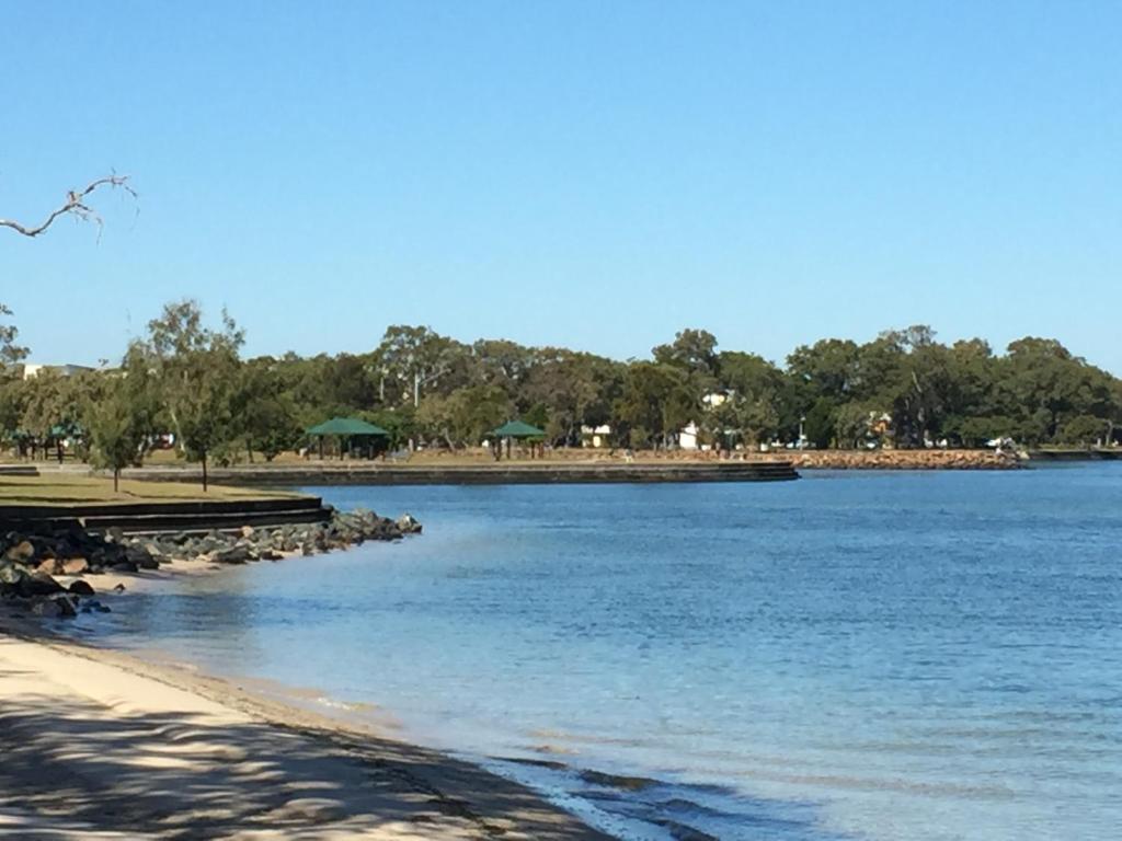 uma vista para um corpo de água com uma praia em Bribie Waterways Motel em Bongaree