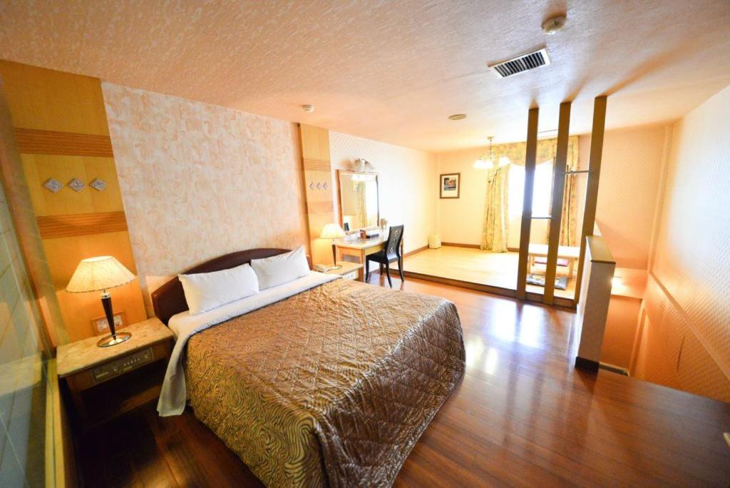 a hotel room with a bed and a desk at Paiwei Motel in Tainan