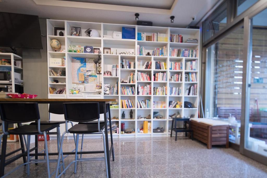 a library with a table and chairs and bookshelves at Dali Yi International Hostel in Toucheng