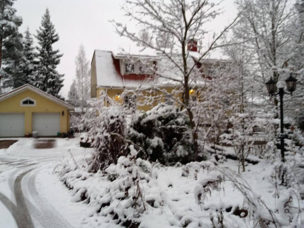 un patio cubierto de nieve junto a una casa en Room in Villa Emilia en Espoo