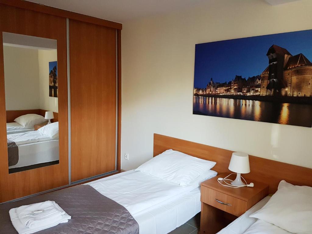 a bedroom with two beds and a large painting on the wall at Ośrodek Wczasowy Bursztyn in Gdańsk