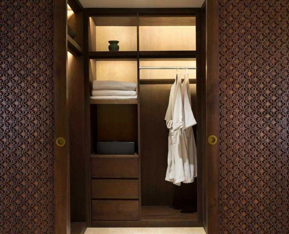 a walk in closet with a robe and towels at Anantara Uluwatu Bali Resort in Uluwatu