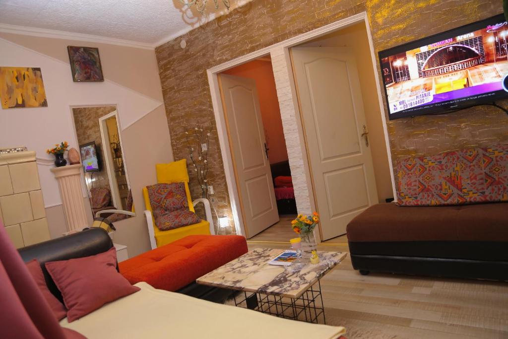 - un salon avec un canapé et une table dans l'établissement Hana Apartments, à Subotica