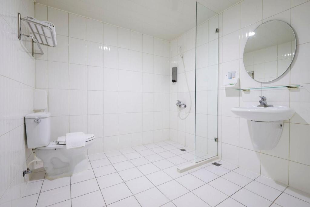 a bathroom with a toilet and a sink and a mirror at Tomorrow Hotel in Taipei