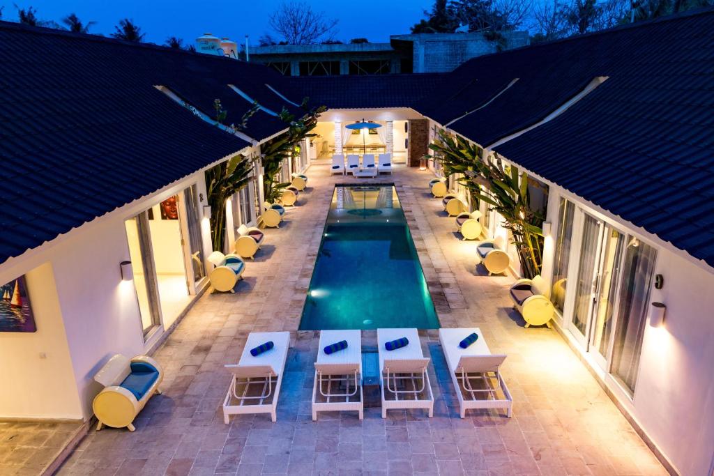 uma vista superior de uma piscina com mesas e cadeiras em Tamoa Boutique Hotel em Gili Trawangan