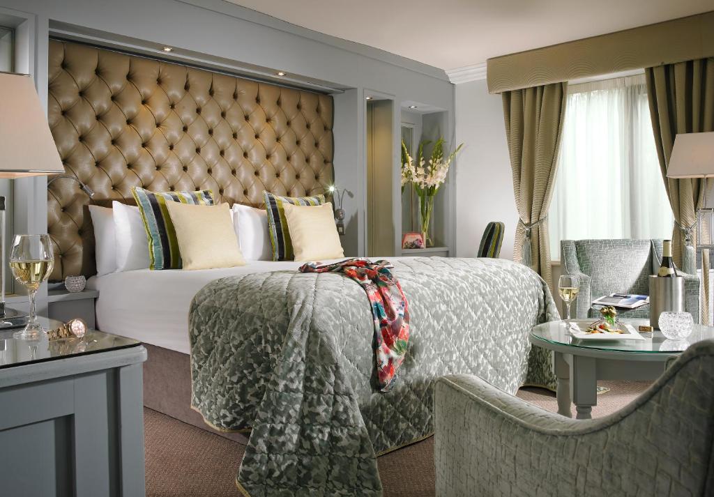 
a hotel room with a bed and a dresser at Newpark Hotel in Kilkenny
