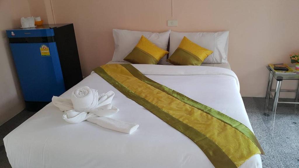 a large white bed with a white flower on it at B and B Hotel in Ranong