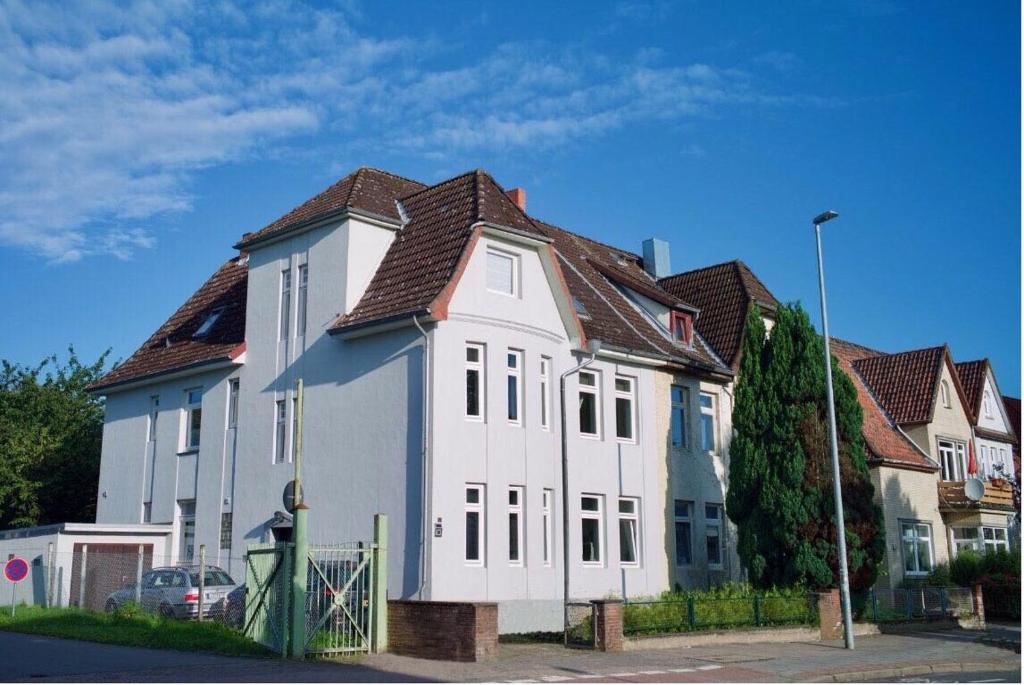 duży biały dom z brązowym dachem w obiekcie Wohnung in Lüneburg w mieście Lüneburg