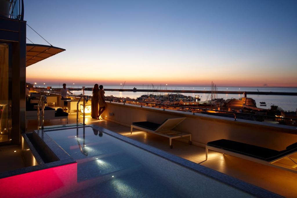 a rooftop swimming pool with a view of the ocean at Palazzo del Corso – Boutique Hotel in Gallipoli