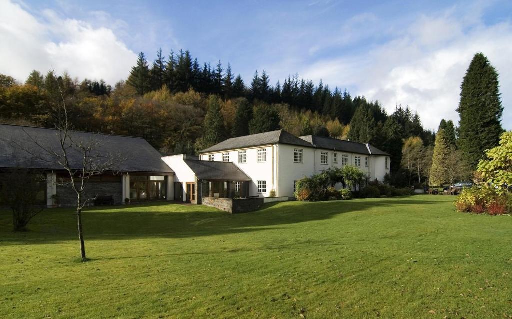 a large white house in the middle of a yard at Nant Ddu Lodge Hotel & Spa in Merthyr Tydfil