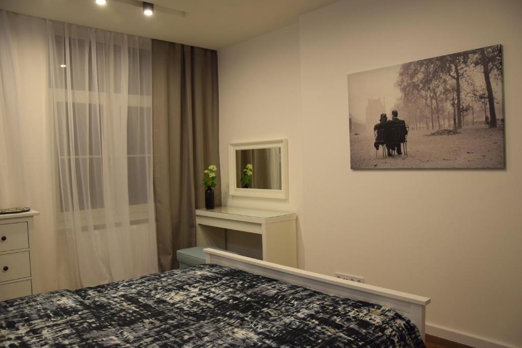 a bedroom with a bed and a picture on the wall at Apartament Marii Ludwiki in Koszalin