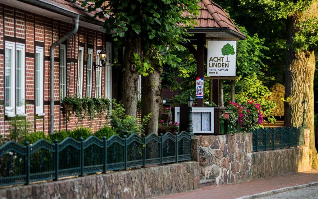 a building with a fence and a sign on it at Hotel Acht Linden in Egestorf