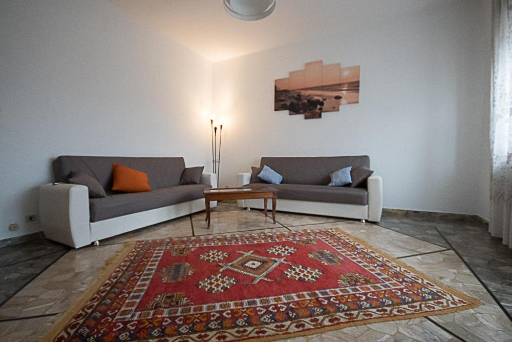 una sala de estar con 2 sofás y una alfombra en Affittacamere Serravalle Shopping, en Serravalle Scrivia
