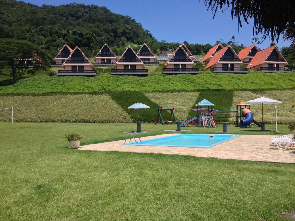 a resort with a pool and a playground and a house at Tureck Garten Hotel in Corupá