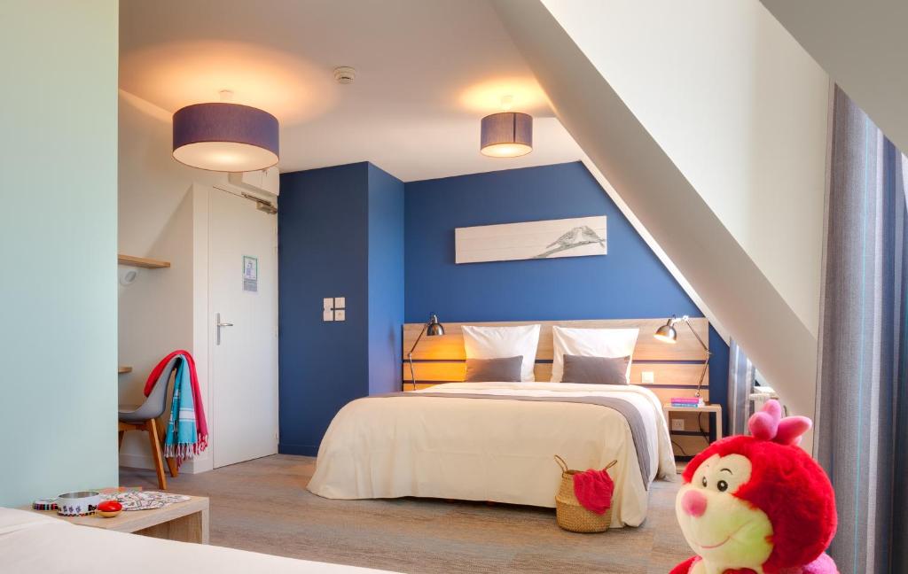 1 dormitorio con paredes azules y 1 cama con un animal de peluche en Village Vacances de Pen-Hir en Camaret-sur-Mer