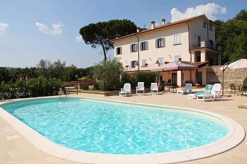 a large swimming pool in front of a house at Agriturismo Casale Zuccari in Caprarola