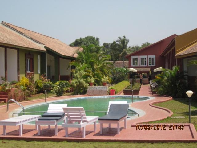 una piscina con tumbonas junto a una casa en J.RENTALS VILLA 33, en Anjuna