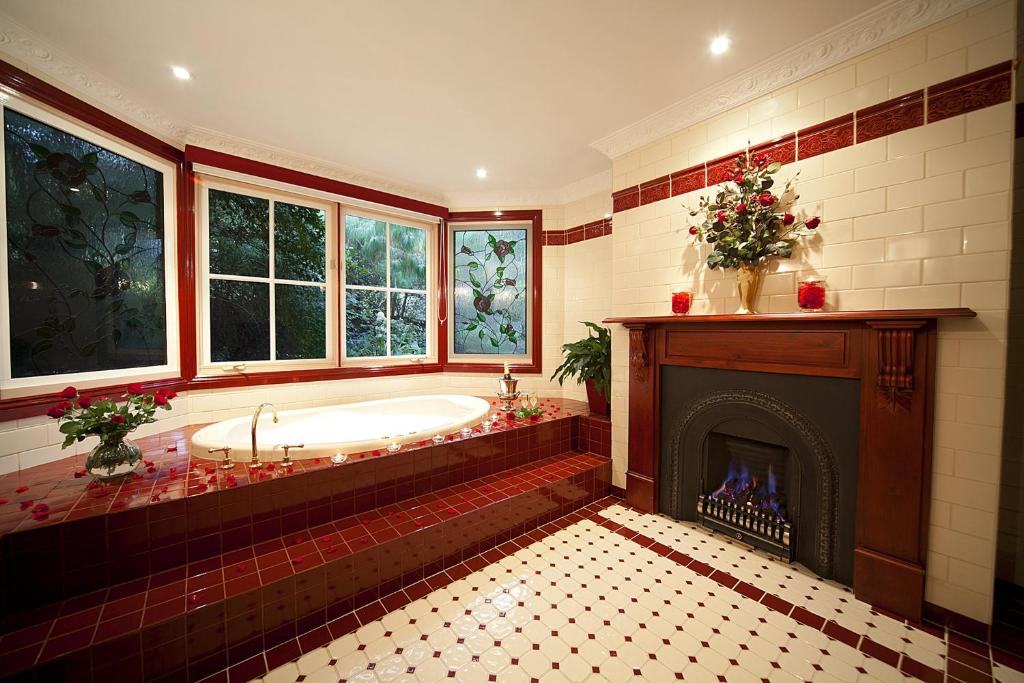a large bathroom with a tub and a fireplace at Mountain Whispers Leura Rose in Leura