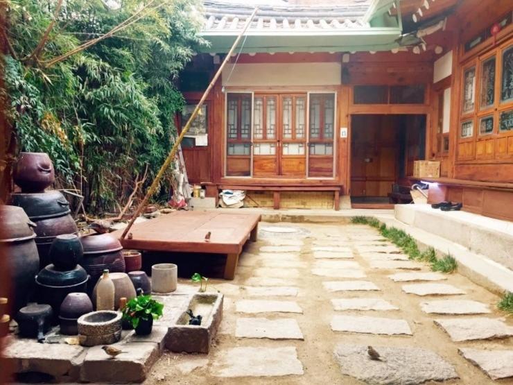 um pátio de uma casa com um banco e um sidx sidx em Gongsimga Hanok Guesthouse em Seul