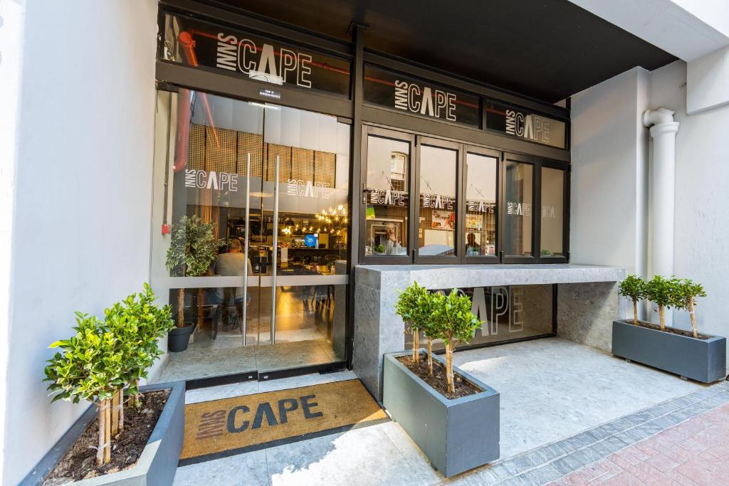 a store front with potted plants in front of it at InnsCape on Castle Hotel in Cape Town