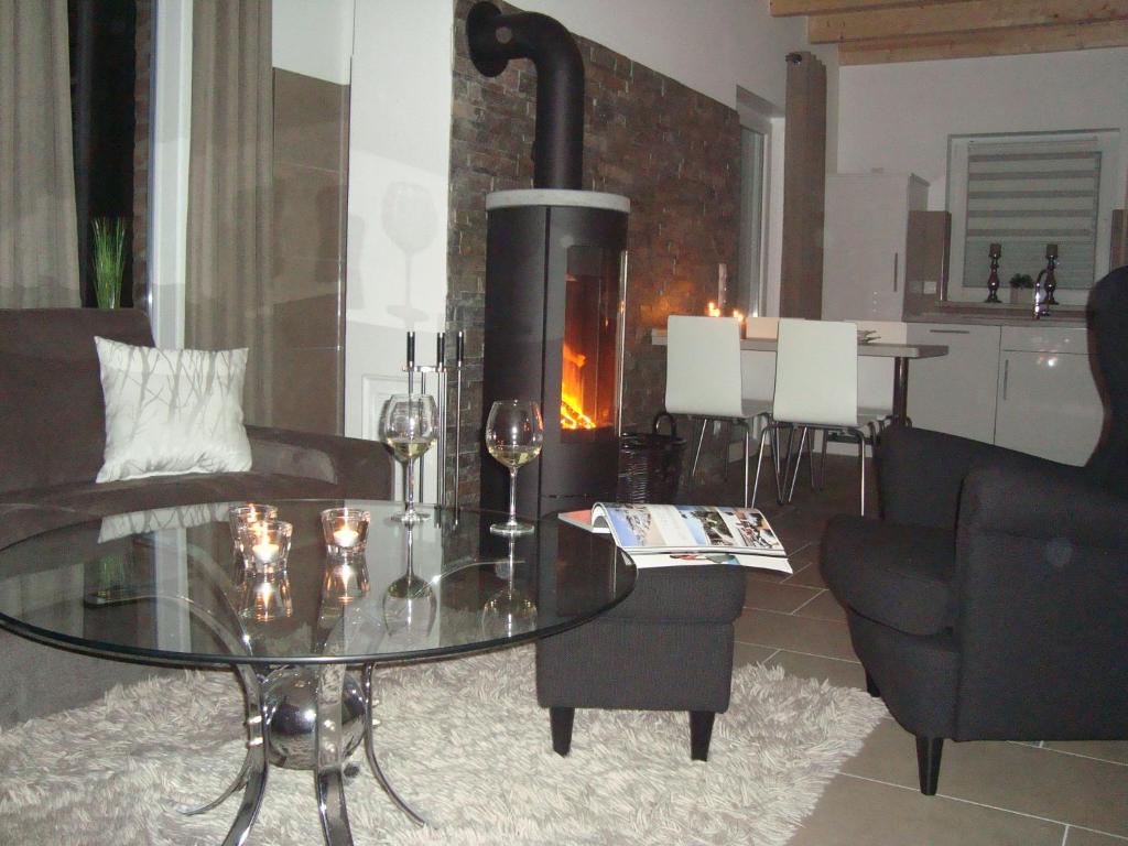 a living room with a glass table and a fireplace at Strandlust in Petersfeld