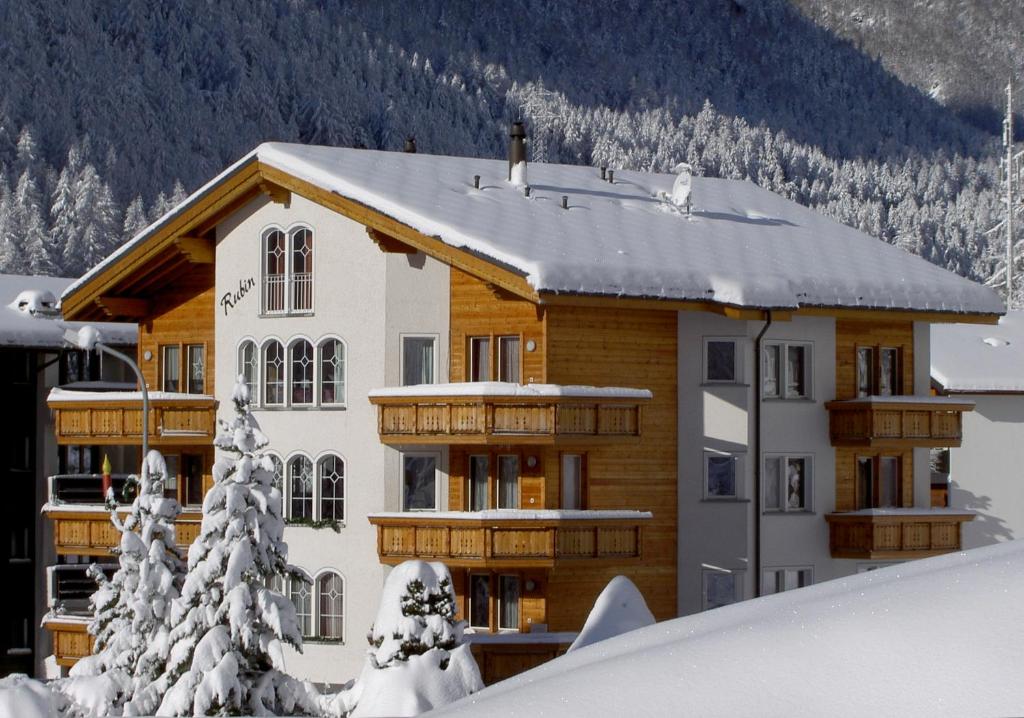 ein Haus im Schnee mit schneebedeckten Bäumen in der Unterkunft Haus Rubin in Saas-Almagell