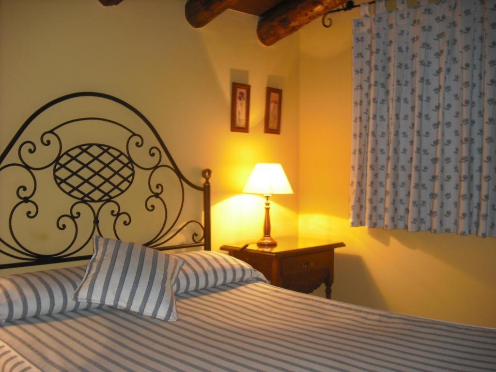 ein Schlafzimmer mit einem Bett und einer Lampe auf einem Tisch in der Unterkunft Casa de Oria in Albarracín