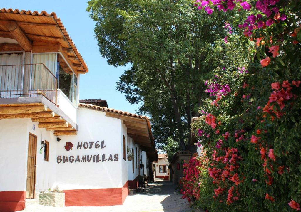 a building with a sign for a hotel and flowers at Hotel Bugamvillas Tapalpa in Tapalpa