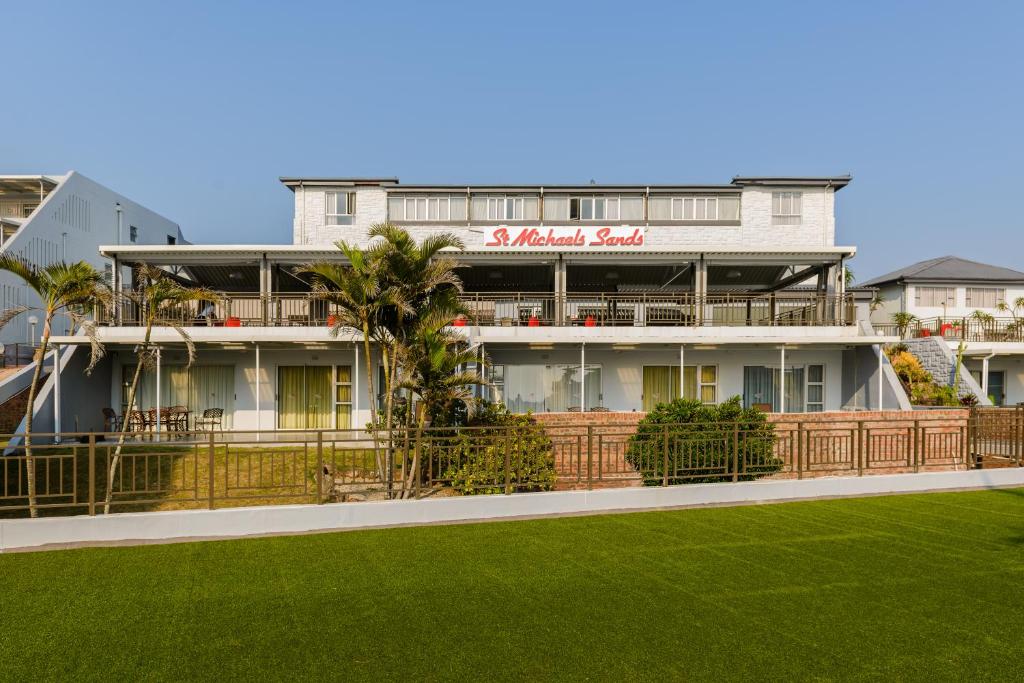 a building with a green lawn in front of it at St Michaels Sands Hotel & Time Share Resort in Shelly Beach