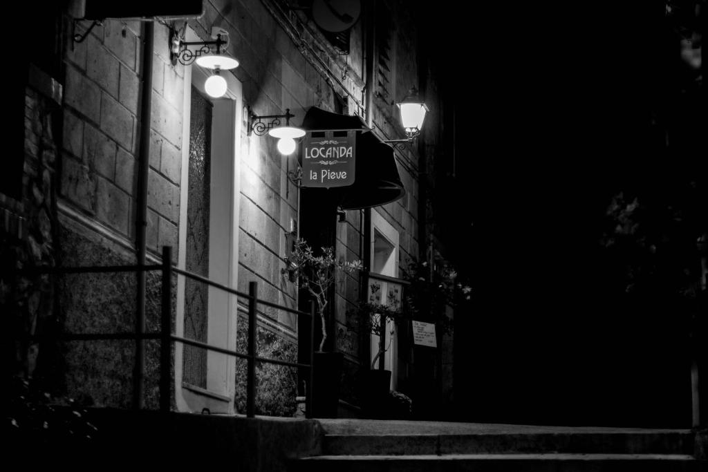un letrero de la calle al lado de un edificio por la noche en Locanda La Pieve, en Semproniano