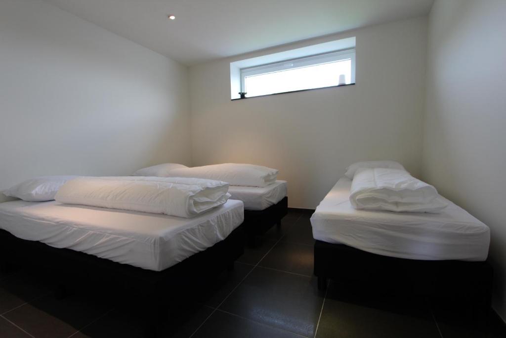 2 aparte bedden in een kamer met een raam bij Nuvola East in Zottegem