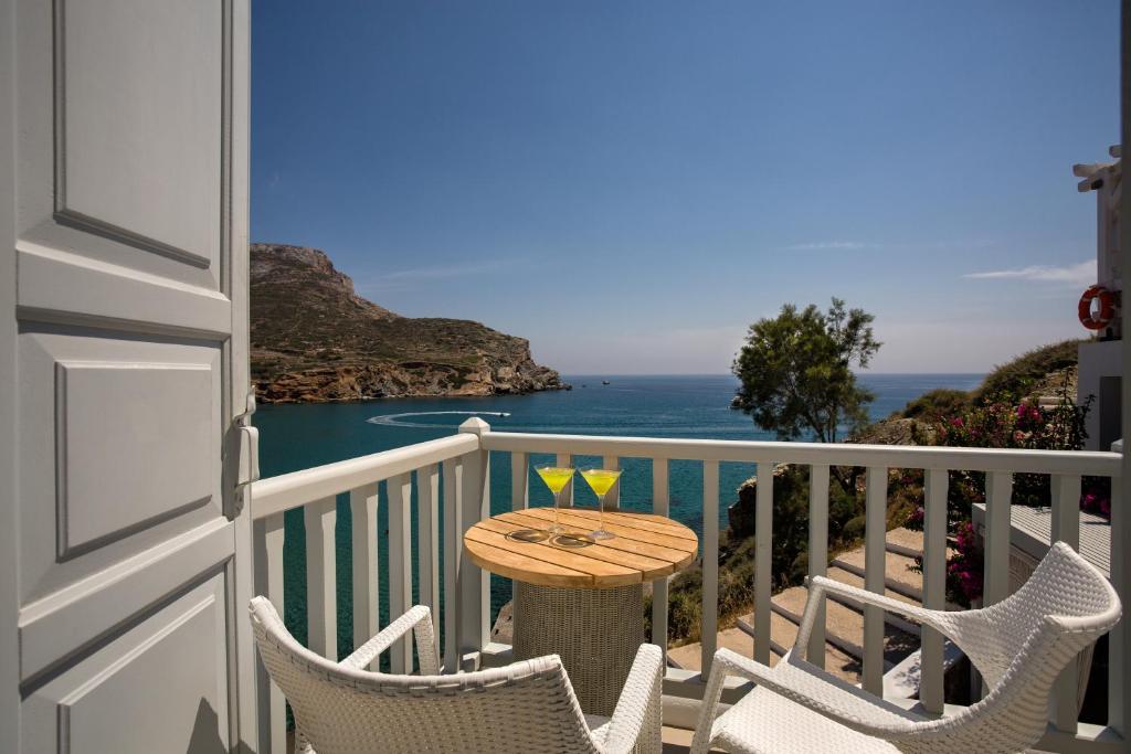 a table on a balcony with a view of the ocean at Blue Sand Boutique Hotel & Suites in Agali