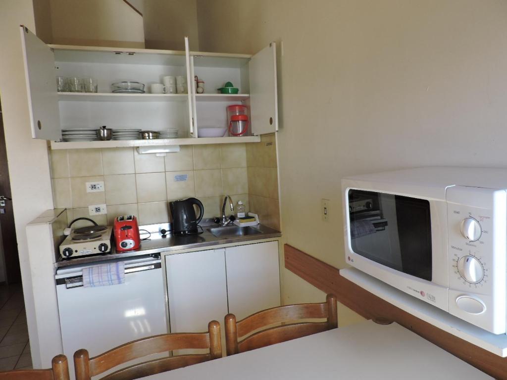 a small kitchen with a microwave and a stove at Apart Las Lenas in Las Lenas