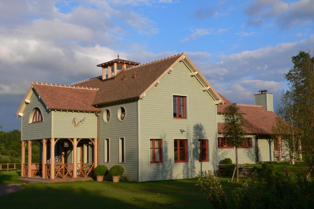 une grande maison blanche avec un toit marron dans l'établissement Lodge Saint-Hymer, à Saint-Hymer
