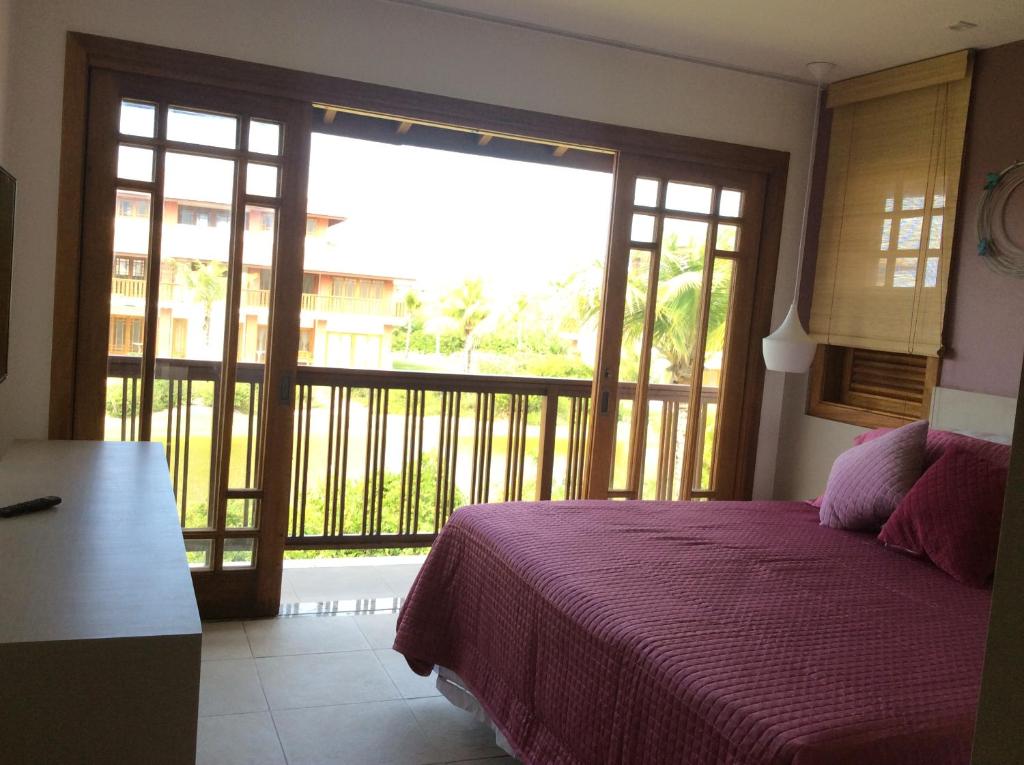 una camera da letto con un letto e vista su un balcone di village na praia do forte a Praia do Forte