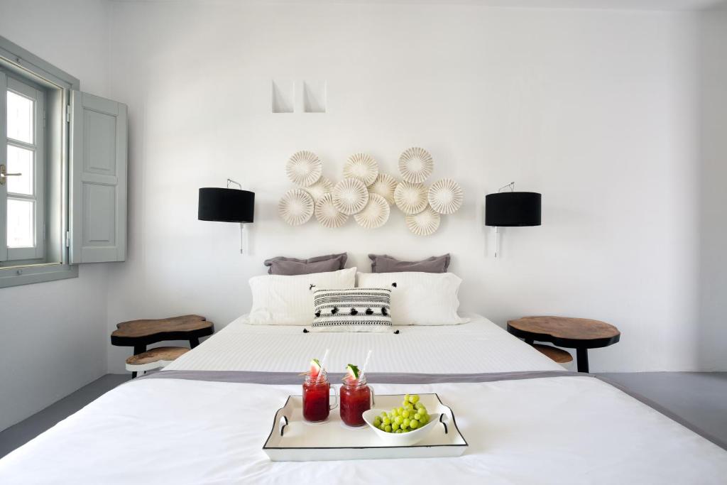a white bed with a tray of fruit on it at Blue Sand Boutique Hotel & Suites in Agali