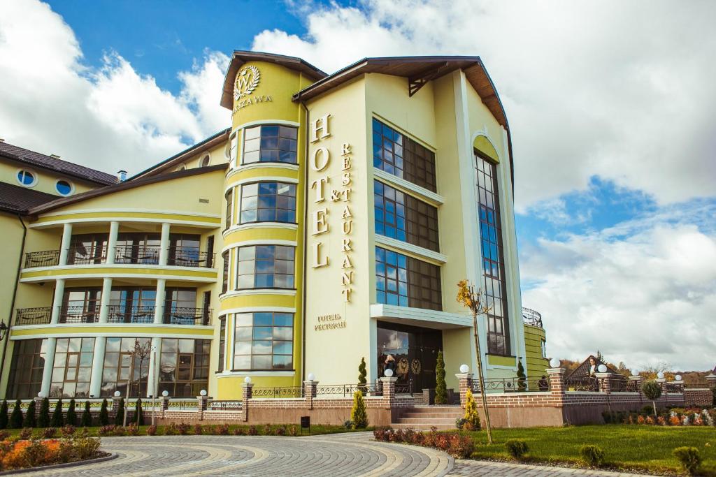 un edificio blanco y amarillo con un letrero. en Warszawa Hotel, en Leópolis