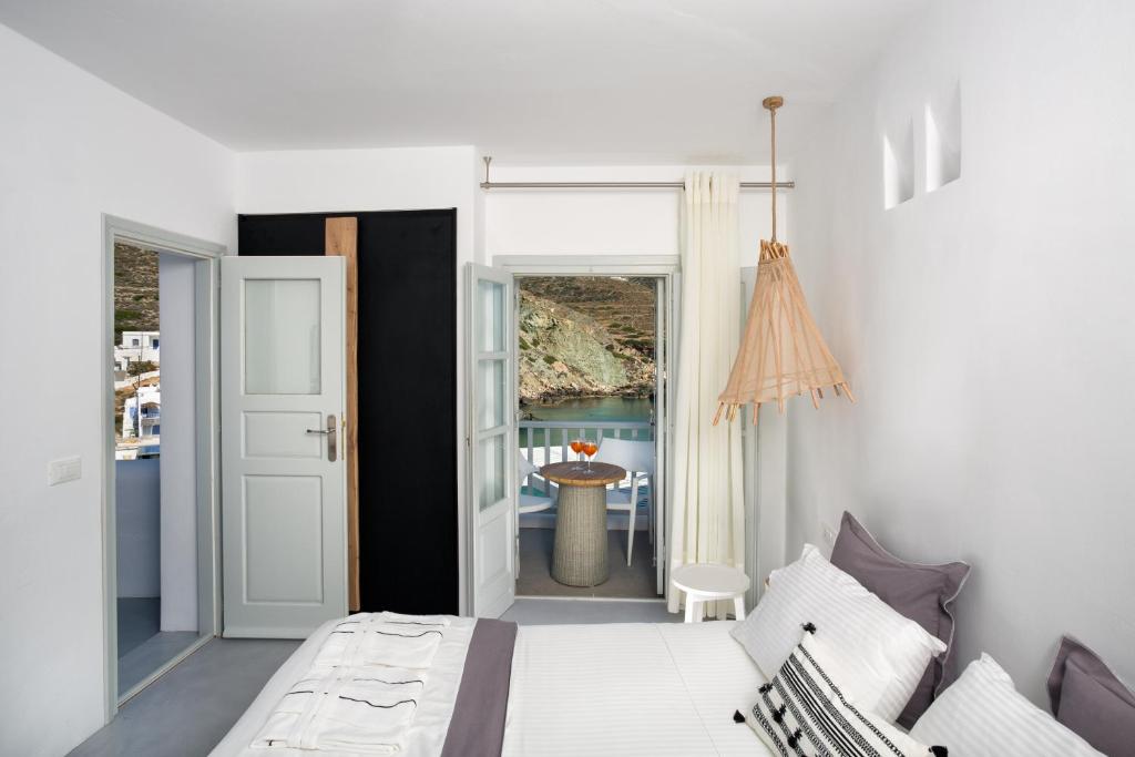 a white bedroom with a bed and a balcony at Blue Sand Boutique Hotel & Suites in Agali
