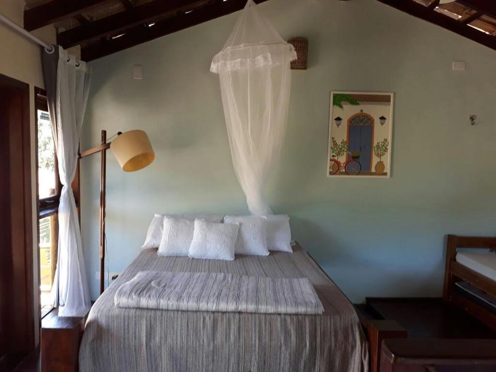 Säng eller sängar i ett rum på Mandacaru Chalés e Suítes Itamambuca
