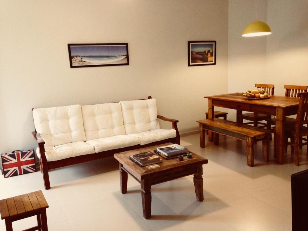 sala de estar con sofá y mesa en Apartamento Cabo Frio 3Q, en Cabo Frío