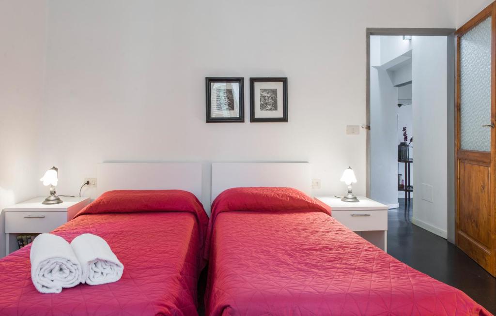 フィレンツェにあるBorgo La Noce Florenceのベッドルーム1室(ベッド2台、赤いシーツ、タオル付)