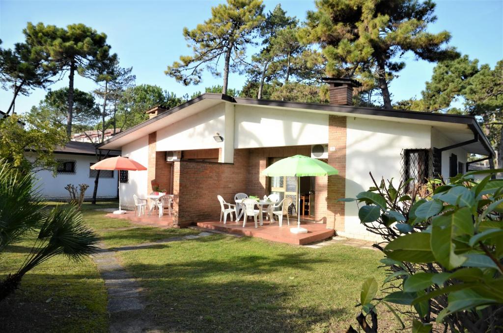 リニャーノ・サッビアドーロにあるVillaggio Gioveのテーブルとパラソル付きのパティオが備わる家