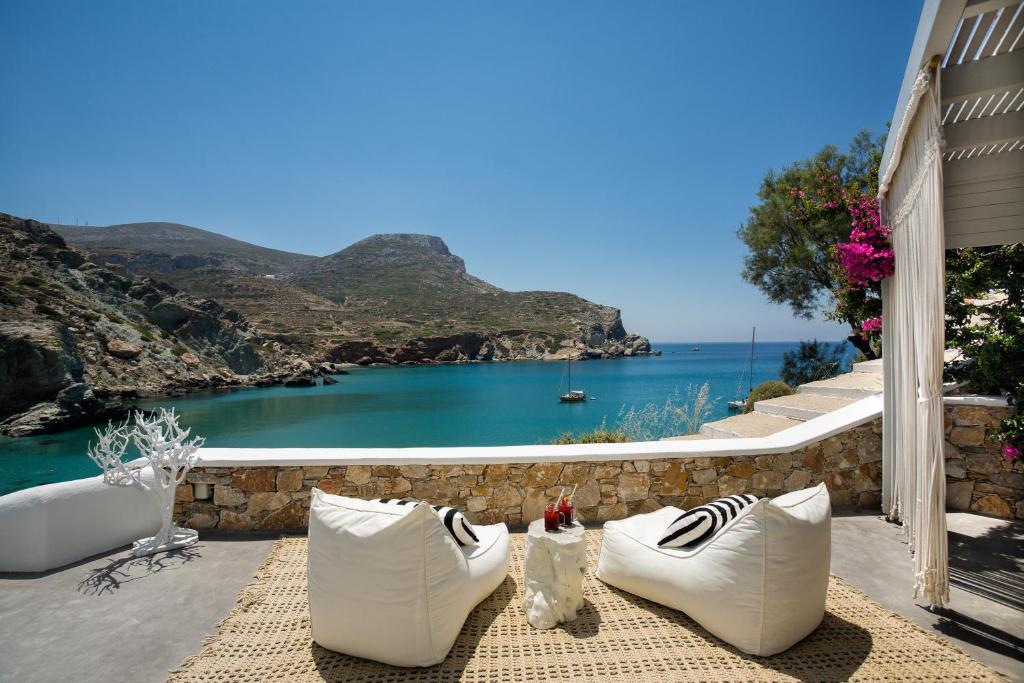 eine Terrasse mit weißen Stühlen und Meerblick in der Unterkunft Blue Sand Boutique Hotel & Suites in Agali