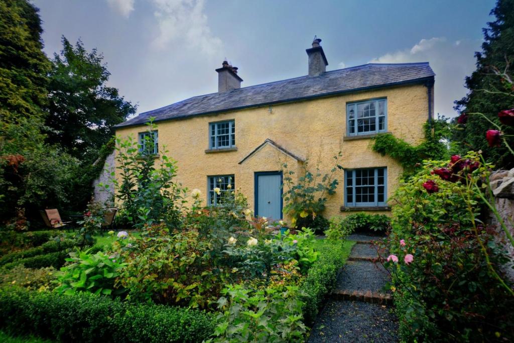 an old house with a garden in front of it at Knocknalosset House in Canningstown