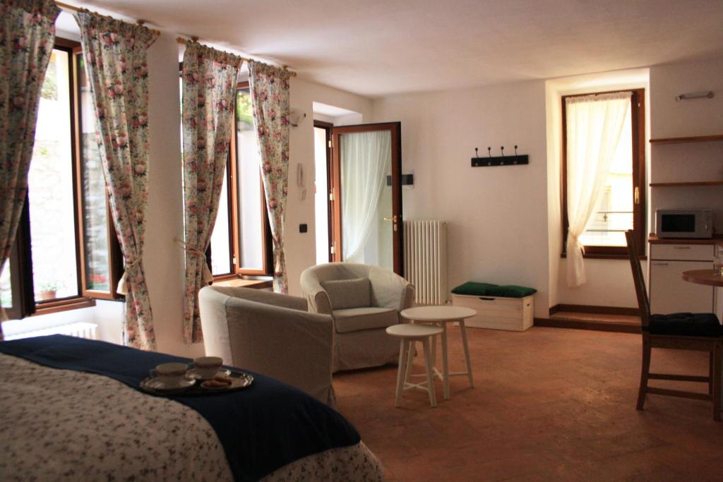 een slaapkamer met een bed, een stoel en ramen bij Imbarcadero Apartment in Bellagio