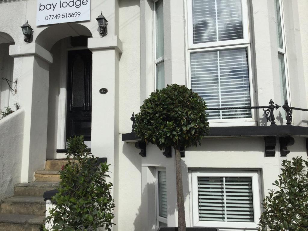 a white house with a plant on the side of it at Bay Lodge in Aylesbury