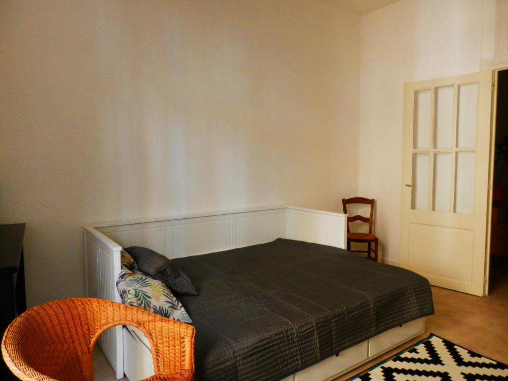 ベルジュラックにあるCouette & Café Roxaneのベッドルーム1室(ベッド1台、オレンジ色の椅子付)