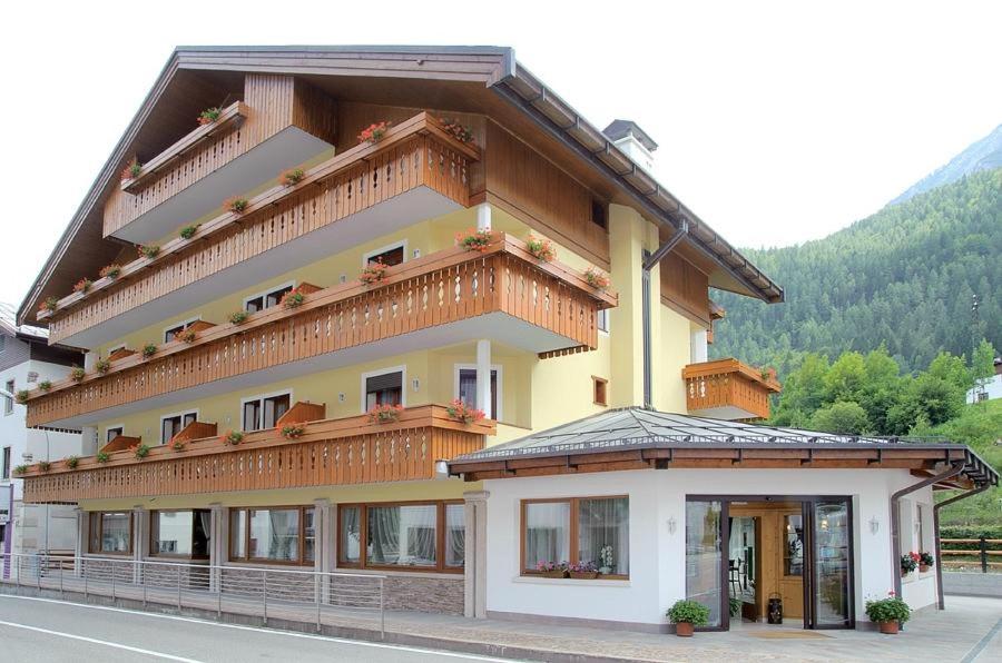 ein großes Gebäude mit Balkon darüber in der Unterkunft Hotel Garnì posta in Forno di Zoldo