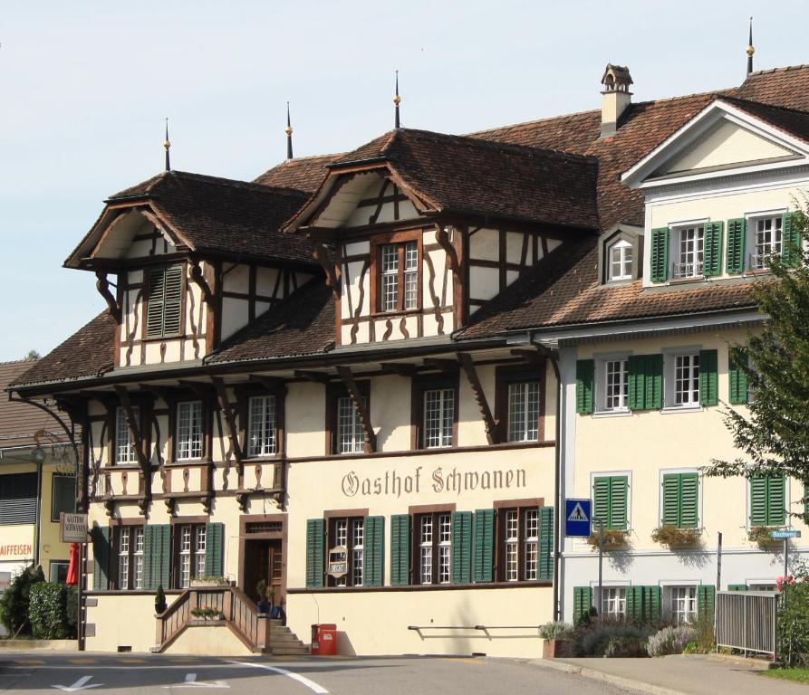 un edificio antiguo con persianas verdes en una calle en Landgasthof Schwanen, en Merenschwand